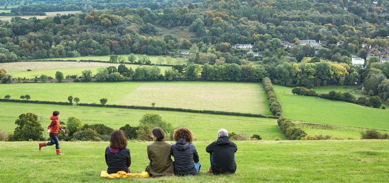 Adults sit and enjoy the view of green fields